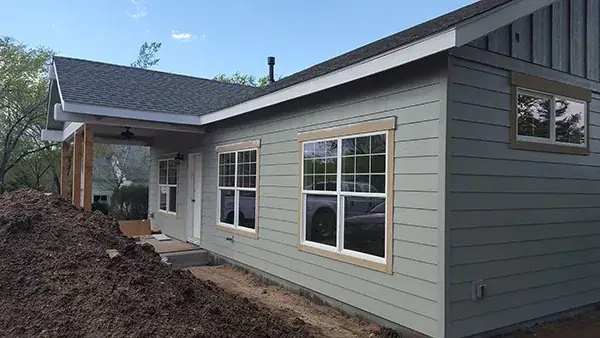 Side view of a finished custom home with lap siding and covered porch in Northern Arizona