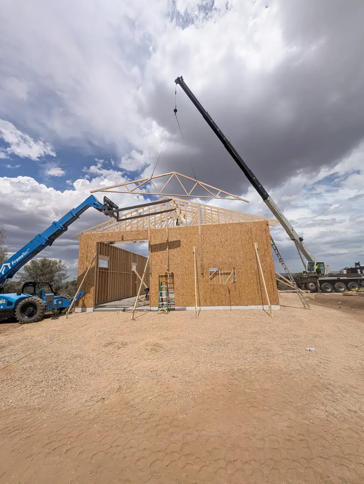 Crew framing a new home with a crane on a Northern Arizona lot