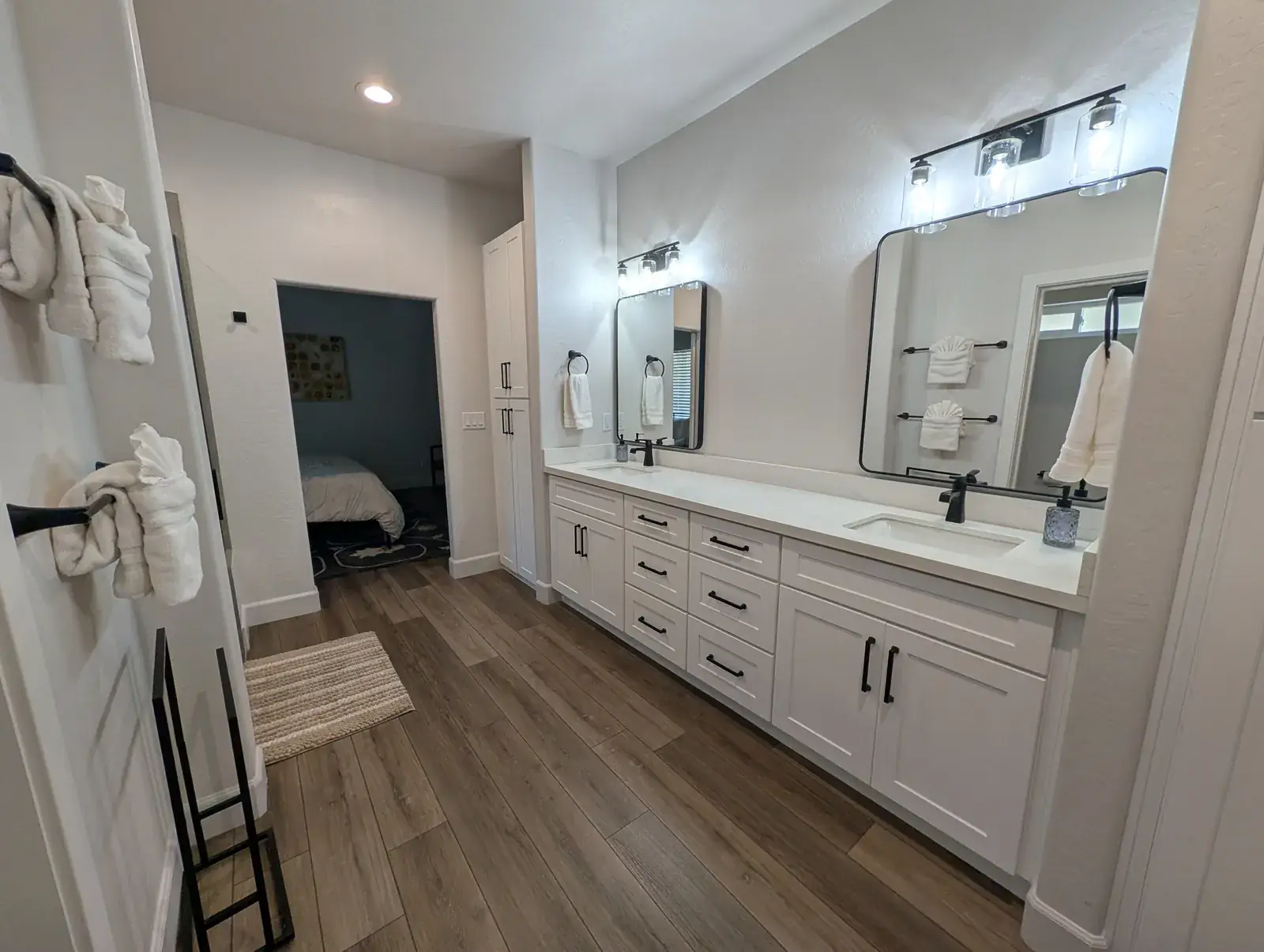 Primary bathroom with double vanity and wood-look flooring
